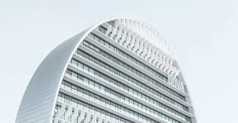 A white building, suitable for real estate investments, with a curved shape.