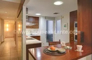 A 128m2 apartment in the center of Alicante featuring a kitchen with a wooden table and chairs.