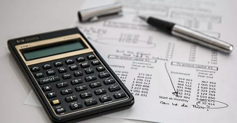 A calculator sits on top of a piece of paper, calculating the cost of owning Spanish property.