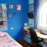 A budget-friendly townhouse in Orihuela Costa, Villamartin with a small bedroom featuring blue walls and a desk.