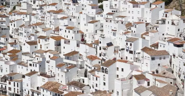 An aerial view of a picturesque town in Spain with properties available for sale.