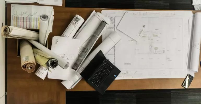 A desk with blueprints for a new build property in Spain.