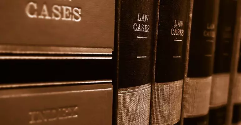 A stack of books about law cases, including resources for buying a property in Spain and the necessary documents needed for acquisition.