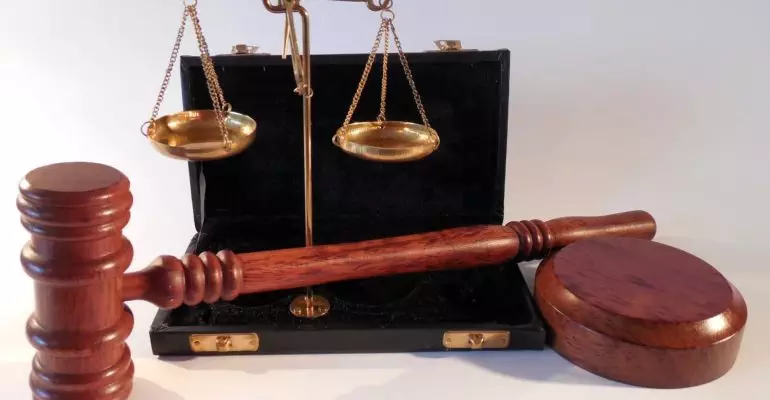 A judge's gavel and a briefcase representing property law in Spain on a white background.