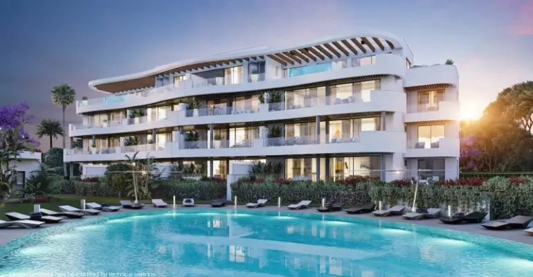 A newly built apartment complex with a swimming pool and lounge chairs, available for sale in Fuengirola or Malaga.