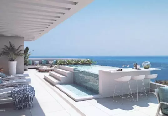 A rendering of a balcony with lounge chairs and a view of the ocean.