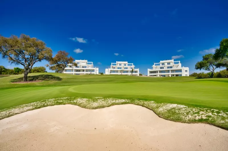 A golf course featuring a sand bunker.