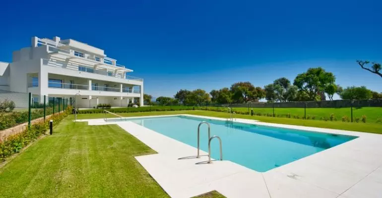 A San Roque penthouse with a swimming pool in front of it.