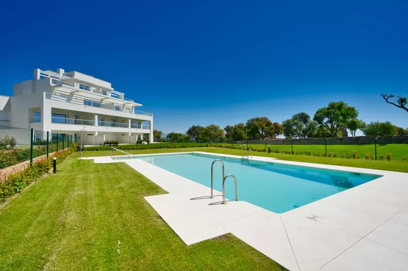 A San Roque penthouse with a swimming pool in front of it.