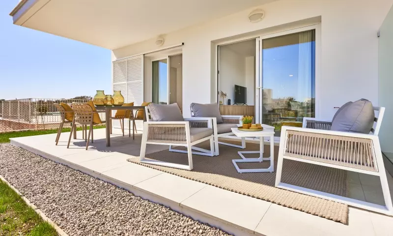 New build apartment in Cala d'or with a patio featuring a table, chairs, and glass door.