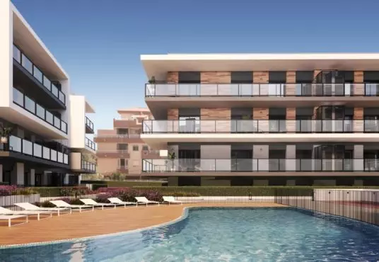 A rendering of a new build apartment complex with a swimming pool for sale in Alicante.