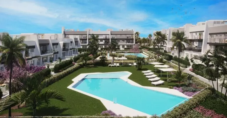 An Alicante New Build Apartment complex with a swimming pool and lawn.