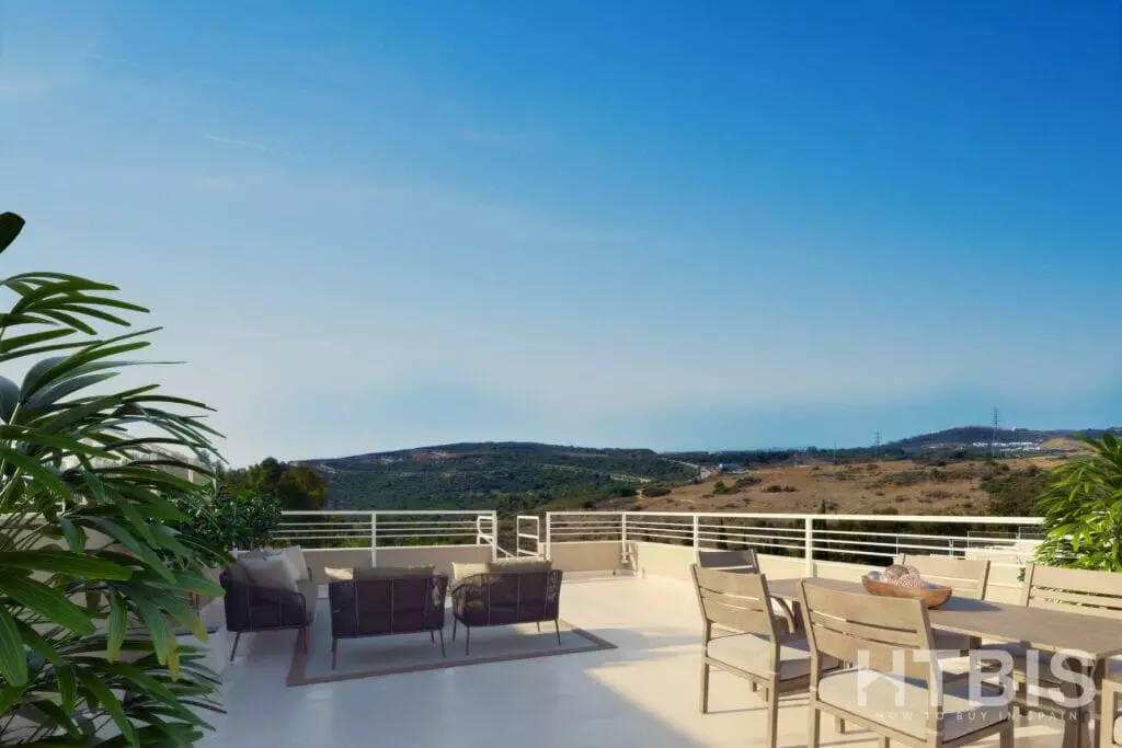 A balcony with furniture and a view of the mountains overlooking the Estepona Golf Course.