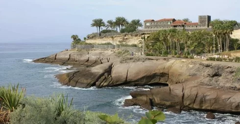 A property in Tenerife with a rocky cliff near the ocean.