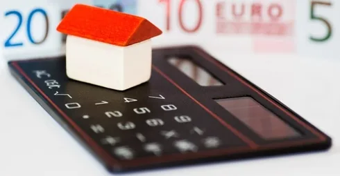 A calculator with a house model on it.