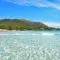 A top Spanish beach with clear water and a mountain in the background.