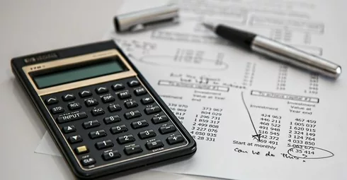 A calculator sits on top of a piece of paper used for calculating Spain property tax.